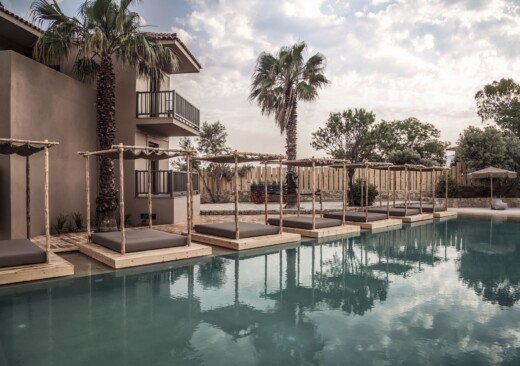 The pool and surrounding sun loungers and palm trees at Doryssa boutique hotel in samos