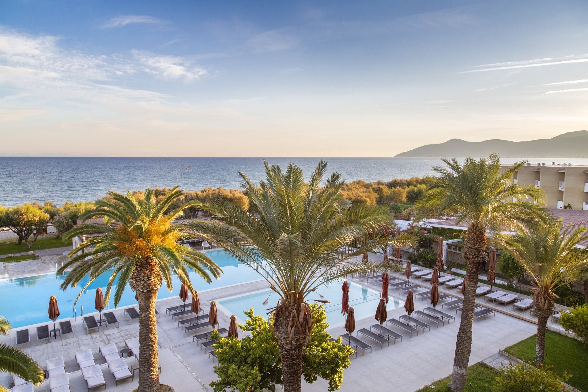 Collection of Doryssa luxury hotels in Samos main pools surrounded by palm trees