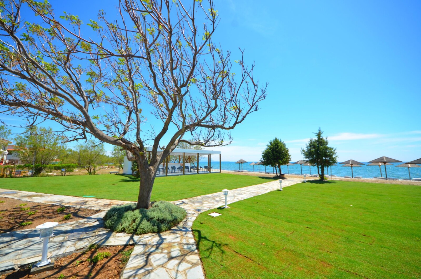 Paved pathway leading to the beach at Doryssa Coast, seafront luxury apartments in Samos